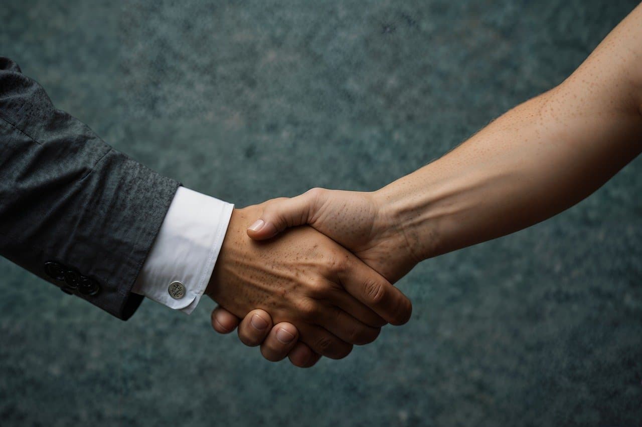 Two people shaking hands as a sign of customer retention.